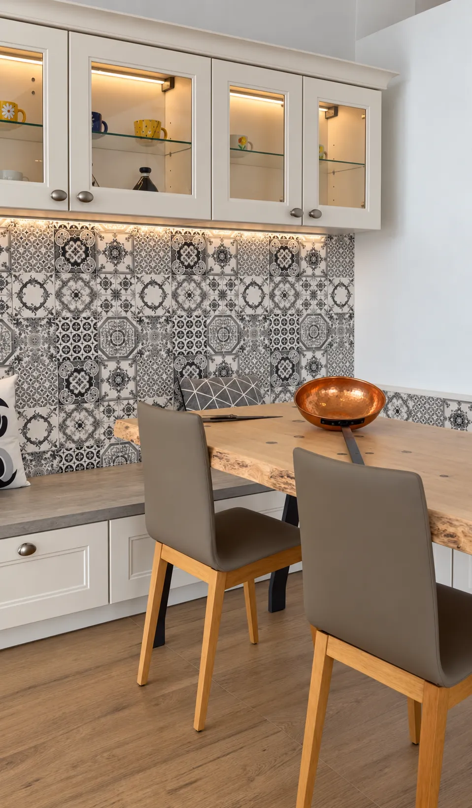 Vitrinas de cristal iluminadas sobre un banco integrado en una cocina de inspiración atemporal