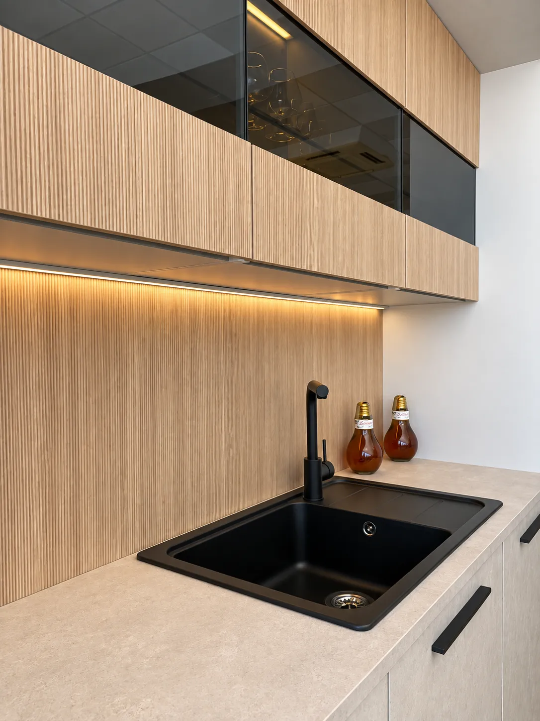 Fregadero y grifo negros junto a muebles efecto cemento en gris cálido